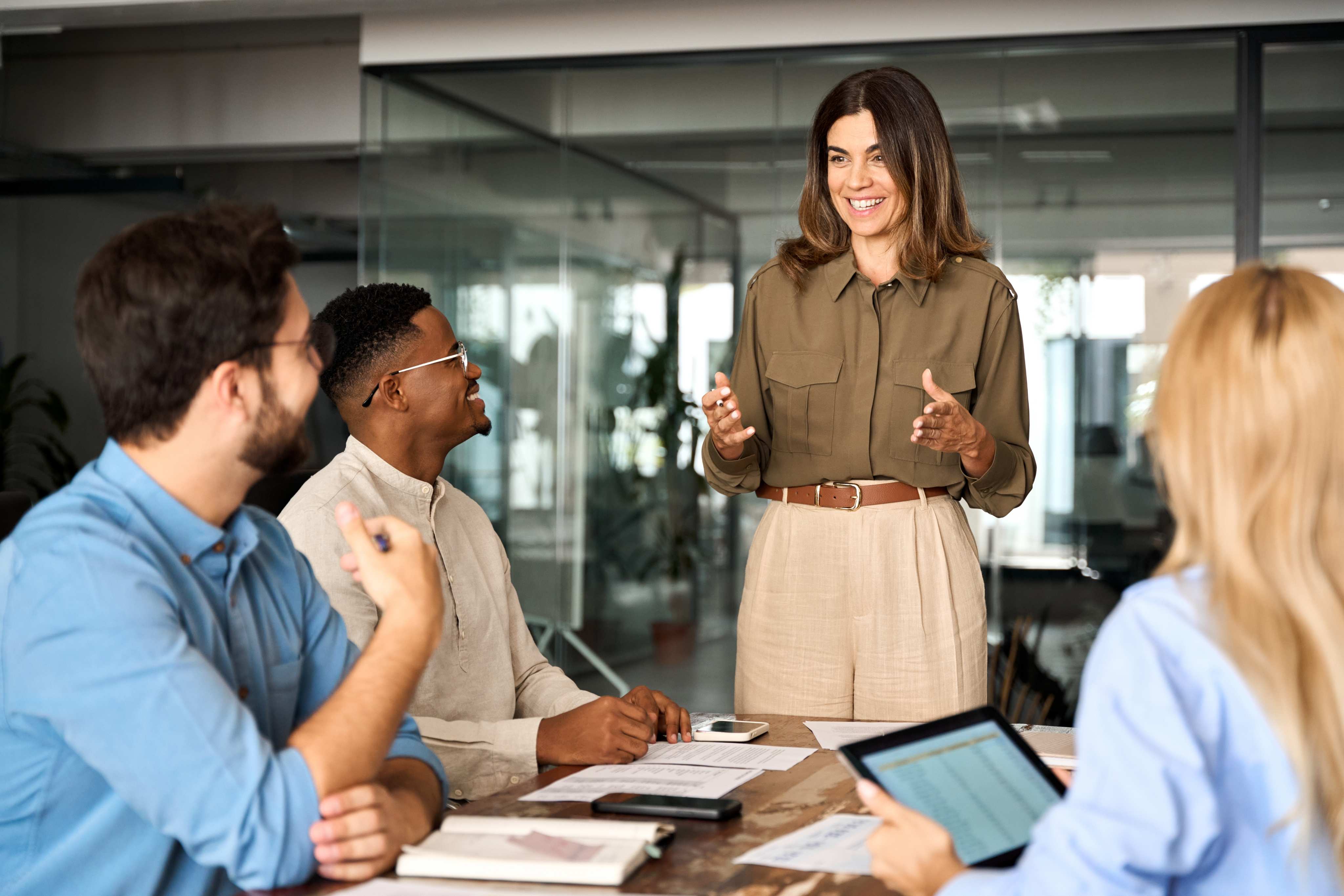 Diverse team of professionals in a modern office meeting room collaborating on projects